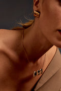 Close-up of model’s neck wearing Celeste Pendant Necklace with a blazer
