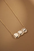 Flatlay of Celeste Necklace highlighting rectangular chain and square pendant