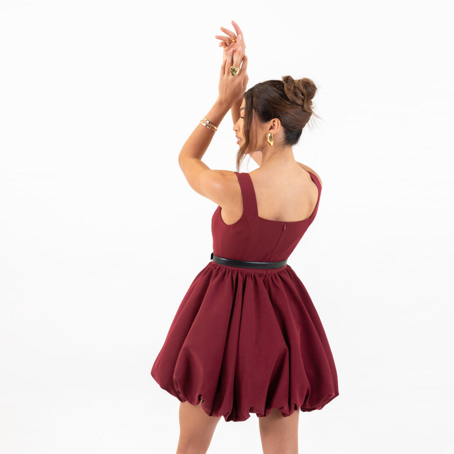 Model wearing Galli The Label Bubble Mini Dress in burgundy with square neckline and playful bubble hem
