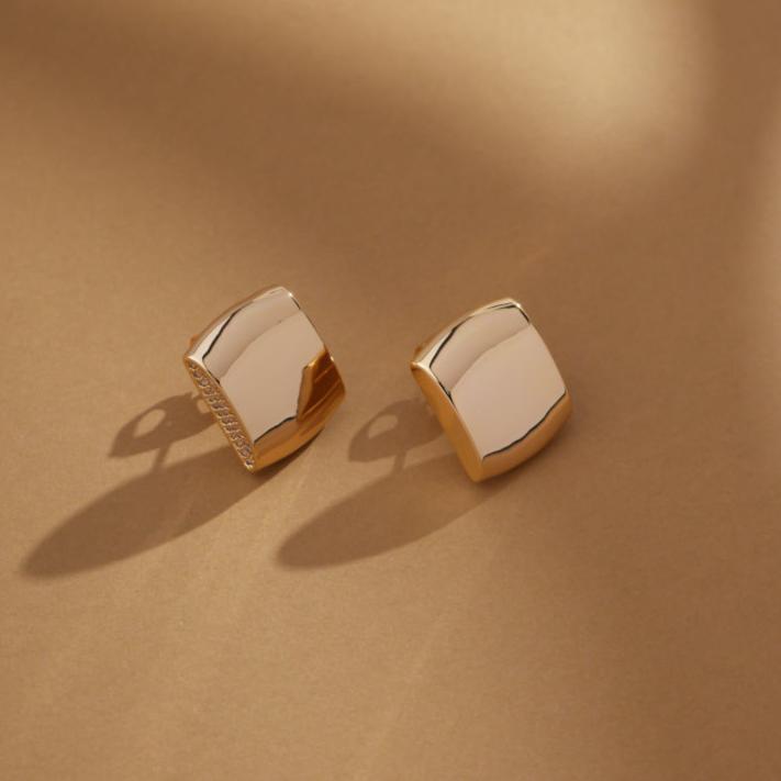 Pair of Gilded Glow square earrings on a neutral-toned surface