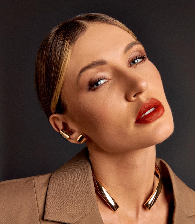 Model wearing Gilded Glow Earrings with a sleek hairstyle and matching choker