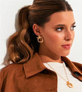 Model wearing Gilded Knot Stud Earrings with brown jacket