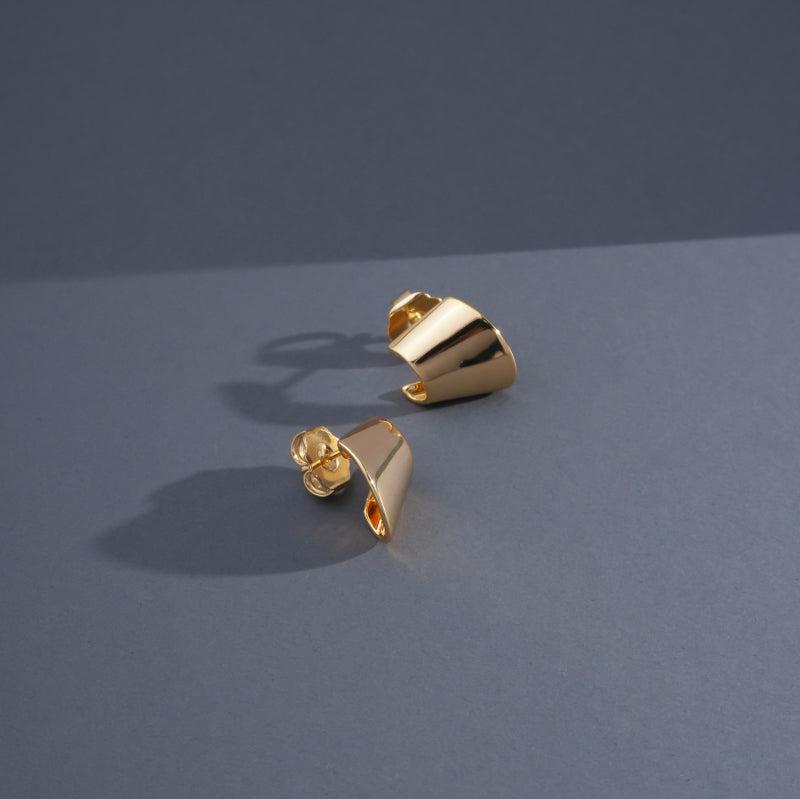 
                  
                    Golden Curve Piercing displayed on blue background
                  
                