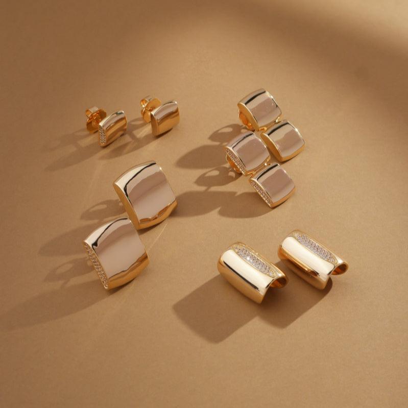 Flatlay of Golden Halo Earrings on a sand-colored surface with scattered crystals