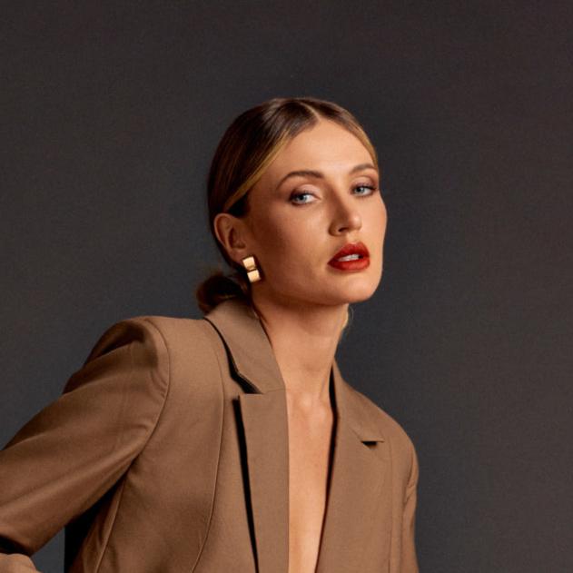 Model wearing Golden Halo Earrings with slicked-back hair and neutral-toned blazer