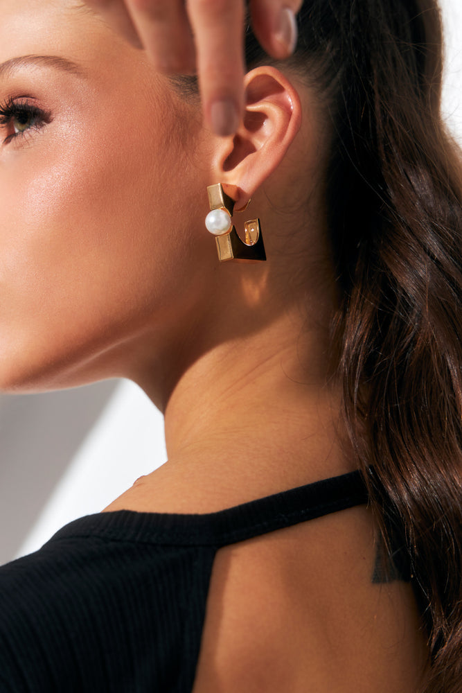 Side profile of model wearing Square Pearl Hoops with hair tied back