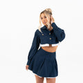 Model in navy set, over-shoulder glance with cuffed sleeves visible