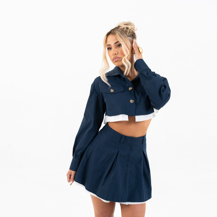 Model in navy set, over-shoulder glance with cuffed sleeves visible