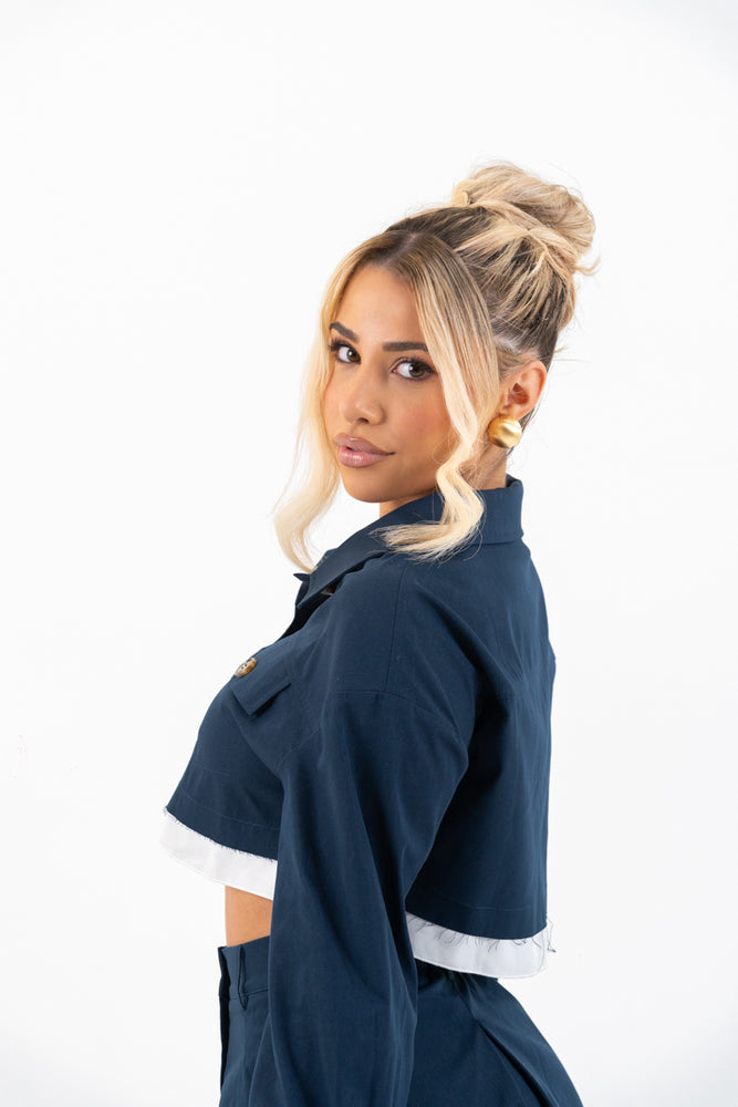 
                  
                    Side view of model in navy set highlighting pleated skirt
                  
                